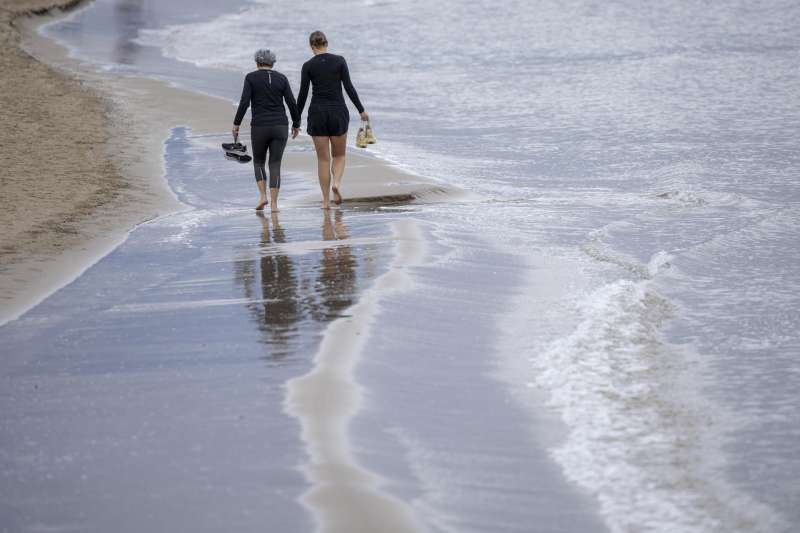 Imagen de archivo de dos personas pasando por una playa.EFEBiel Alio
