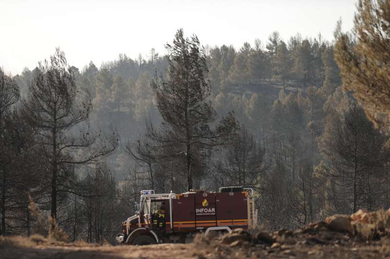 Bomberos en el retn mientras espera el relevo tras pasar la noche trabajando en el incendio en la zona de los Peiros, en la provincia de Teruel. EFEManuel Bruque
