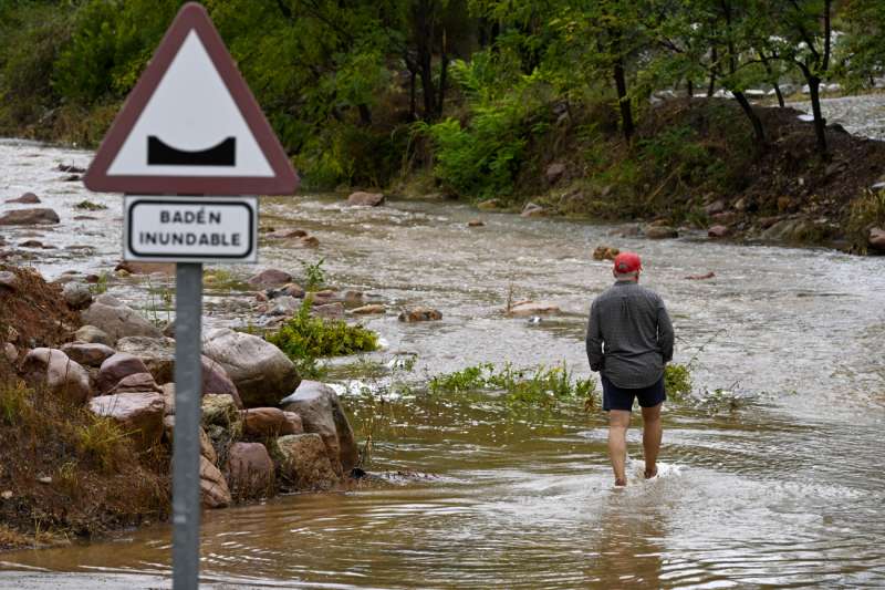 Un hombre cruza un badn inundable durante este lunes en el que el aviso rojo por precipitaciones estar activo hasta la medianoche de hoy en el litoral de la provincia de Valencia, mientras que ha finalizado en el litoral norte de Castelln este medioda. EFEAndreu Esteban