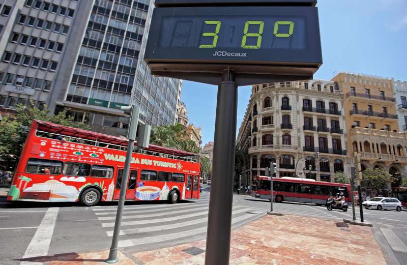 Un autobús turístico circula por el centro de la ciudad de ValÈncia ante un termómetro que marca 38º al sol. EFE/Manuel Bruque/Archivo
