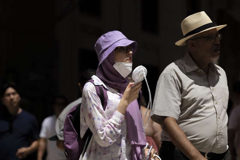 Una mujer combate el calor con un ventilador portÃ¡til en un calle del centro histÃ³rico de ValÃ¨ncia. EFE/Biel AliÃ±o/Archivo
