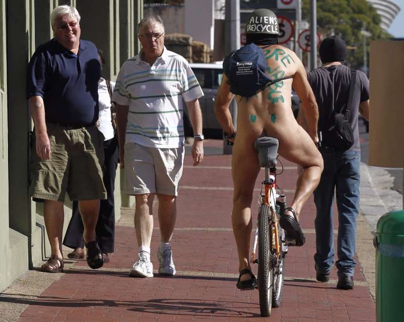 Dos hombres reaccionan al ver a un ciclista desnudo. EFE/Nic Bothma/Archivo

