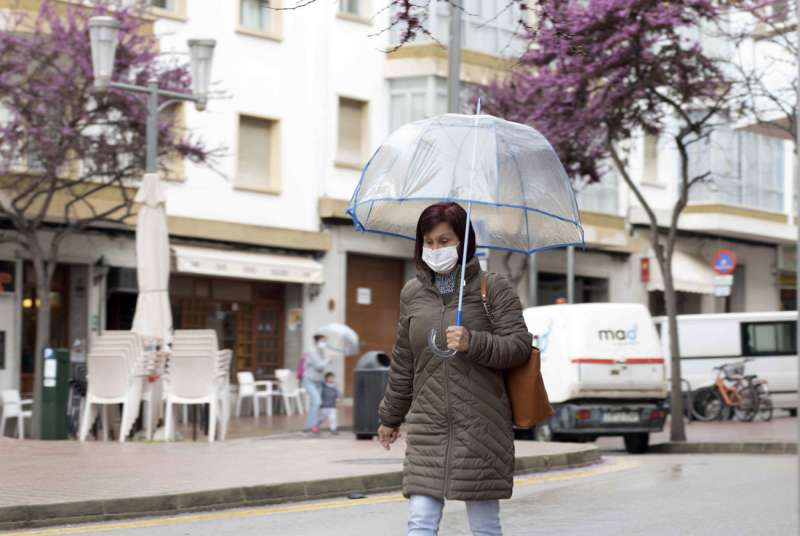 Una mujer pasea abrigada bajo la lluvia. EFE/ David Arquimbau/Archivo

