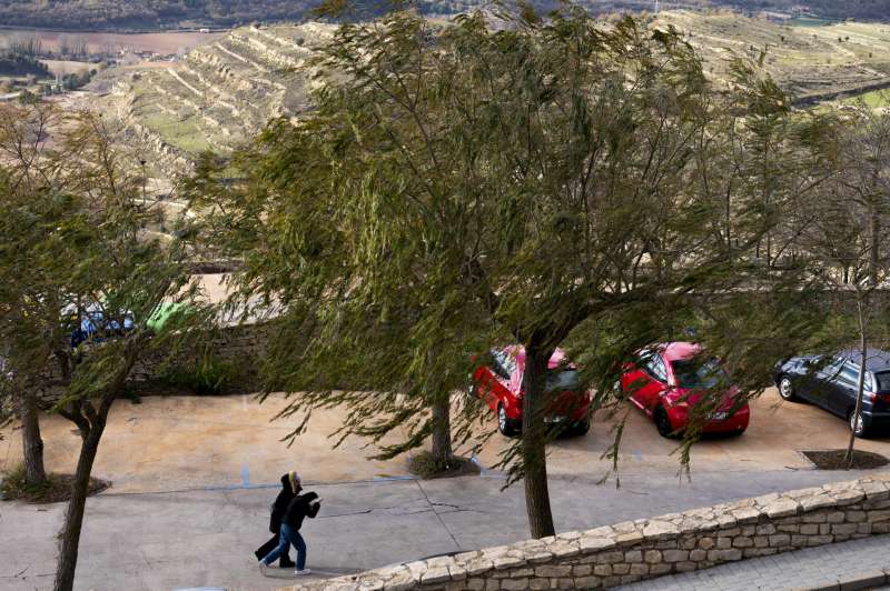 Dos personas pasean contra el viento por Morella. Archivo EFEAndreu Esteban