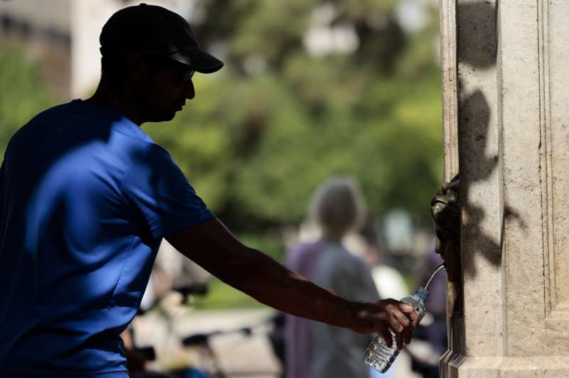 Un hombre rellena una botella de agua en una fuente pblica. EFEAna Escobar
