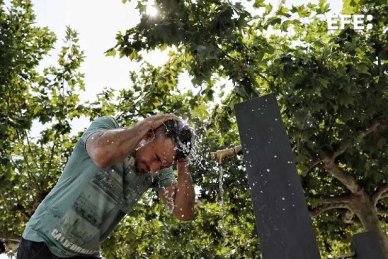 Un hombre se refresca en una fuente para combatir el calor. EFE JESS DIGUES 