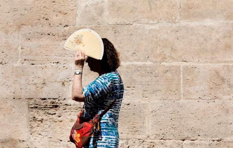 Una mujer se protege del sol en València. EFE/Juan Carlos Cárdenas
