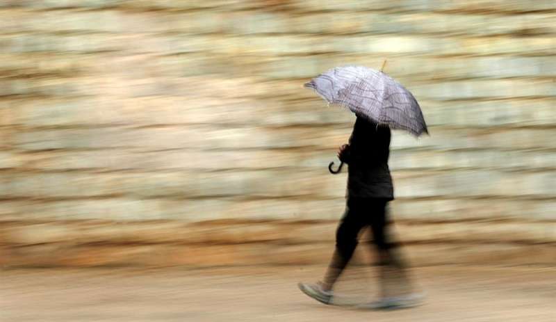 Una persona se protege de la lluvia con paraguas este jueves en València. EFE