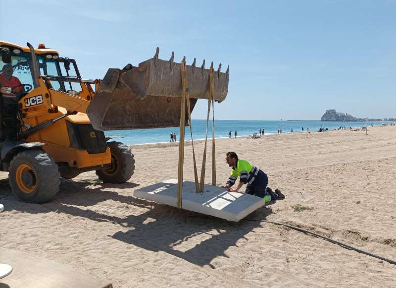 Un operari realitzant tasques a una platja de PenÃ­scola. /EPDA