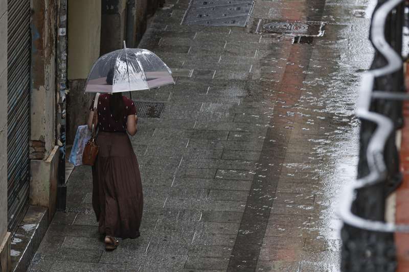 Una persona camina bajo la lluvia  Foto: EFE