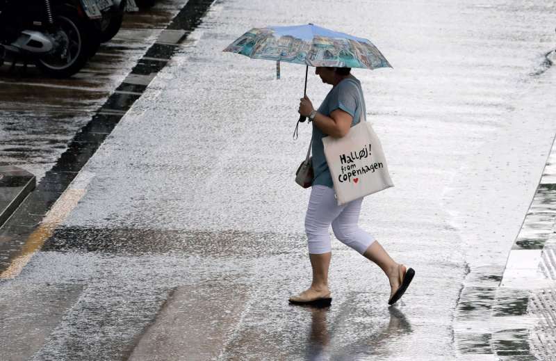 Una persona se resguardan con el paraguas en plena tormenta. Archivo/EFE/ Juan Carlos Cárdenas

