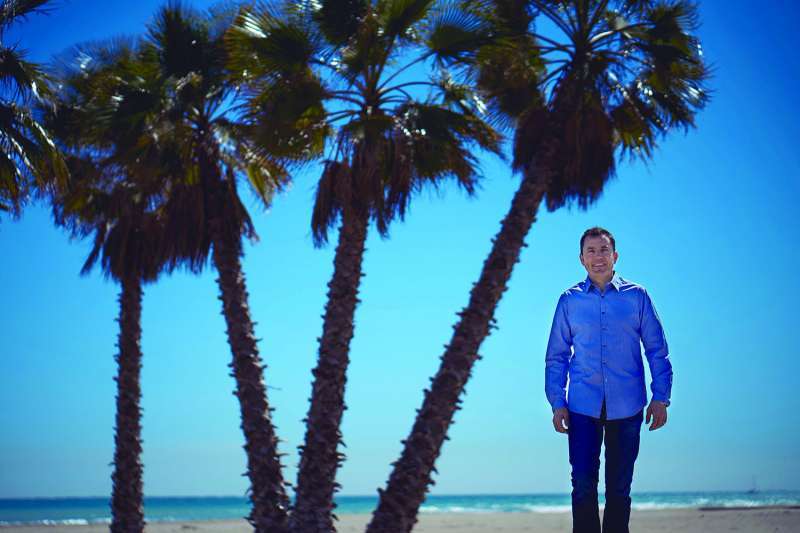 El alcalde de Canet, en la playa junto a las palmeras plantadas en la anterior legislatura. EPDA